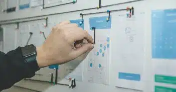 person working on blue and white paper on board